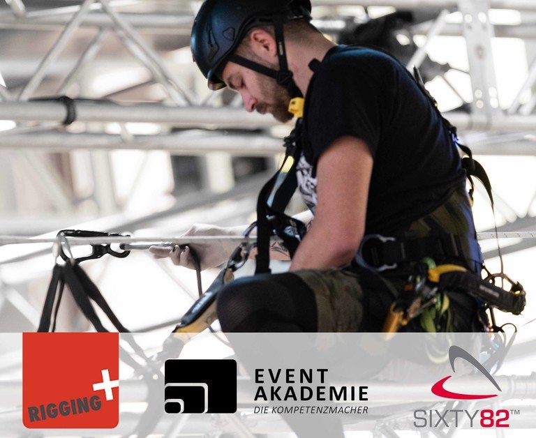 Person mit Helm und persönlicher Schutzausrüstung arbeitet gesichert an einer Traversenkonstruktion und überprüft eine Seil- oder Riggingverbindung. Unten sind die Logos von Rigging+, Event Akademie – Die Kompetenzmacher und Sixty82 eingeblendet.